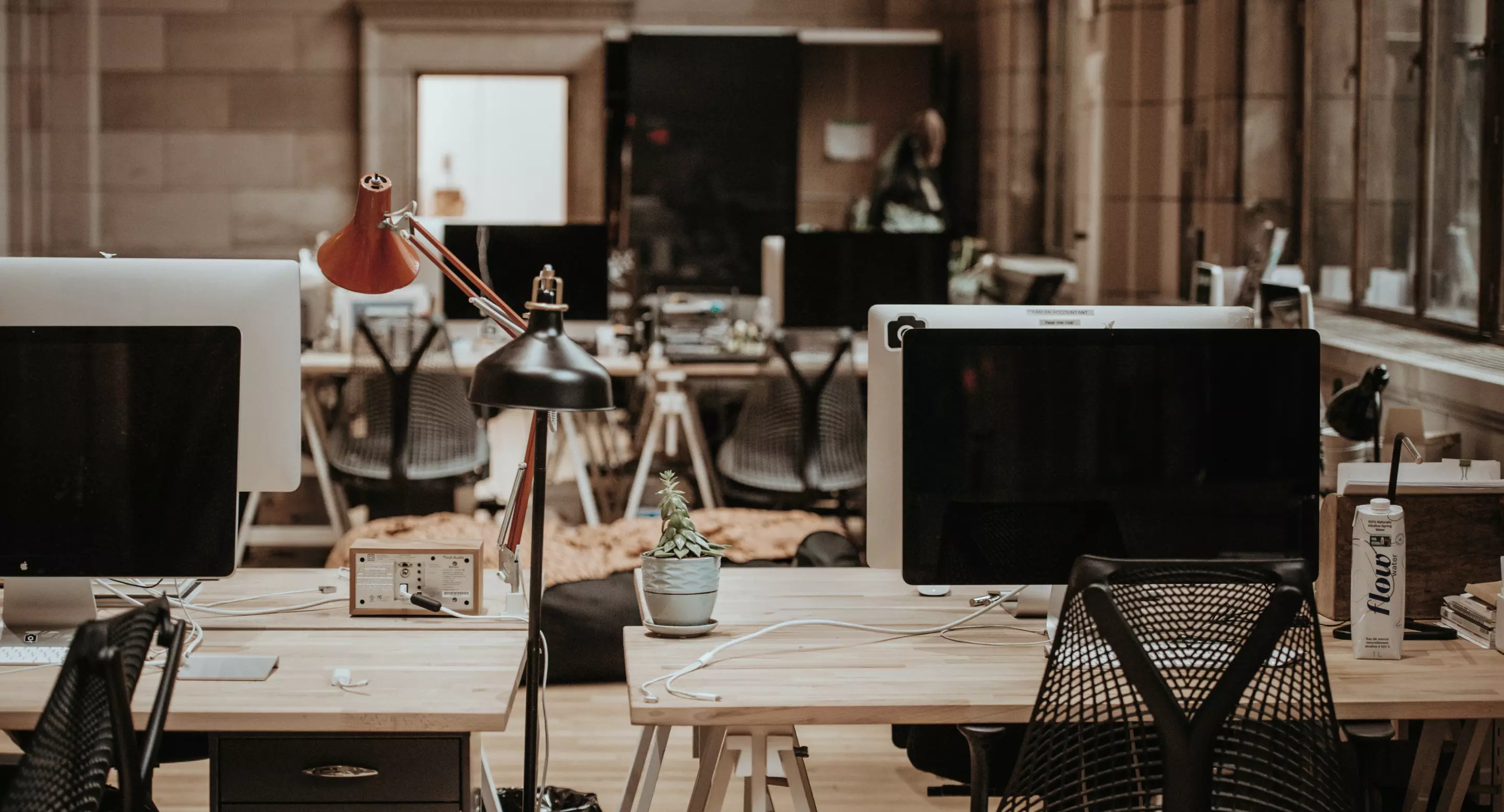 A modern, well-lit office interior with comfortable seating and plants.